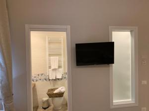 帕加尼Domus Monasteire的墙上设有1间带平面电视的浴室