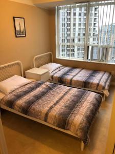 米西索加密西沙加装修公寓酒店的带大窗户的客房内的两张床