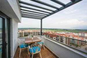 伯萨Kavala Hotel的设有一个配有木桌和椅子的阳台,享有美景。