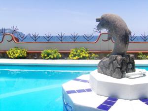 圣帕特里西奥梅拉克La Paloma Oceanfront Retreat的游泳池旁的狗雕像