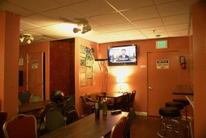 旧金山阿德莱德旅馆 的一间设有桌椅和墙上电视的客房
