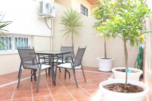 圣玛丽亚港Casa Valdelagrana Playa的庭院配有桌椅和盆栽树木。