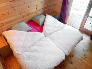 西塞河畔的舒齐La Rossignolerie - POD Cabanes des châteaux的木制客房内的一张床位,配有白色床单和枕头