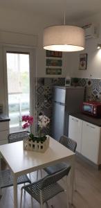 巴勒莫CASA FLORA的厨房配有白色的桌椅和鲜花桌