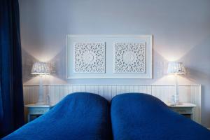 阿姆斯特丹翁德帕克住宿加早餐旅馆的一间卧室配有蓝色床单、两盏灯和一张床