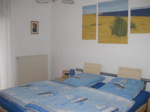 塔廷格Sonnenoase的一间卧室配有一张带蓝色床单和壁画的床。