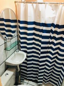 费尔南多 - 迪诺罗尼亚Hostel Ilha do Amor的浴室设有蓝色和白色的浴帘和水槽