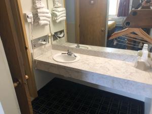 苏华德日落套房酒店的浴室的柜台设有水槽和镜子