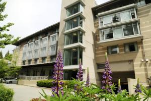 温哥华凯里中心酒店的一座在前面布满紫色花的建筑