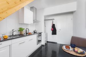 苏黎世Swiss Star Aussersihl - Self Check-In的厨房配有白色橱柜和一张桌子上的食品托盘