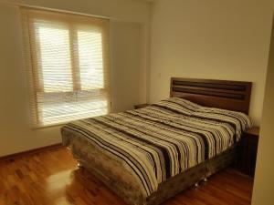 利马Jirón Tarapacá 398, La Punta - Callao的一间卧室配有带条纹棉被的床和窗户