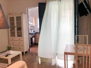 卡拉费尔Casita de Pescador的客厅配有白色窗帘和桌子