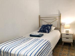 卡拉费尔Casita de Pescador的一间卧室配有一张带蓝白条纹毯子的床