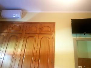 布鲁内特布鲁内特旅舍的一间设有木柜的房间和墙上的电视