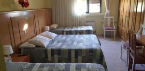 布鲁内特布鲁内特旅舍的带三张床和桌椅的房间