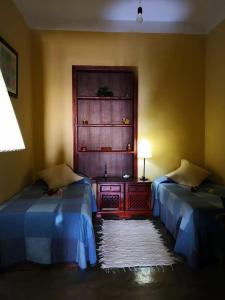巴列埃尔莫索Casa rural Los Órganos de Arguamul的客房设有两张床和一张带台灯的桌子。