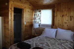 北拉斯蒂科Chalets Grand Pre Cottages的小木屋内一间卧室,配有一张床