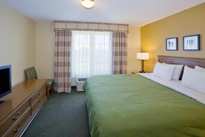 萨利纳萨莱纳江山旅馆及套房酒店的酒店客房设有一张大床和一台电视。