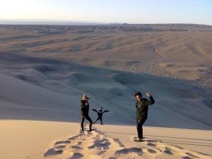 乌兰巴托城市旅馆加旅游的两个人站在沙漠沙丘上