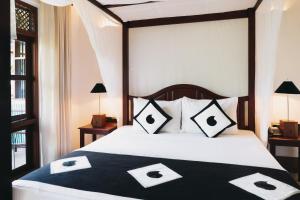 本托塔Amal Beach Hotel的一间卧室配有一张带黑白枕头的床