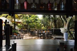 本托塔Amal Beach Hotel的一间设有桌椅和树木的餐厅