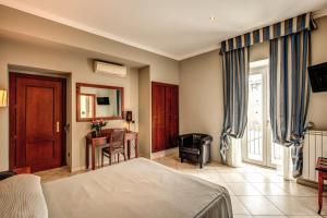 罗马陶尔米纳酒店的一间卧室配有一张床、一张桌子和一把椅子