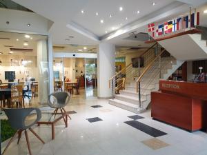 萨拉热窝赫克酒店的大堂设有楼梯、椅子和桌子