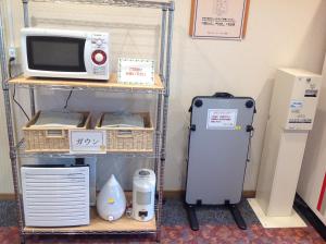 岛田岛田1-2-3酒店的一个带微波炉和冰箱的架子