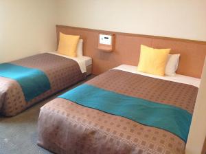 岛田岛田1-2-3酒店的酒店客房带两张黄色和蓝色的床