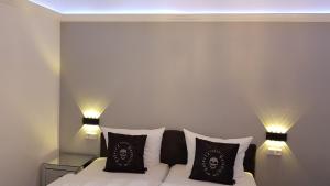 巴特维尔东根Pension Gockels-Auszeit的一间卧室配有带枕头和2盏灯的床。
