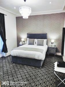 伦敦德里意外之喜别墅酒店的一间卧室配有一张大床和一个吊灯。
