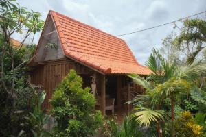 坎古潘德寄宿家庭式酒店的一座带橙色瓷砖屋顶的小房子