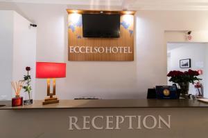 罗马Eccelso Hotel的办公室,设有前台,墙上配有电视