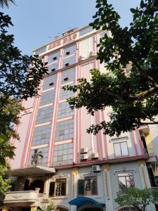Phủ LýKhách sạn Anh Đào的粉红色和白色的建筑,有很多窗户