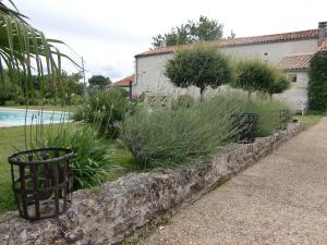 热镇Du Côté de l'Ombrière的游泳池旁的植物挡墙
