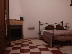 CarpinoneCasa di Emilia的一间卧室配有一张床和一个壁炉