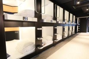 东京Business Capsule Hotel Lightning Hotel Asakusa的宿舍间的一排双层床