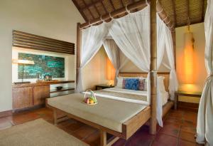 圣吉吉吉娃克鲁度假酒店的一间卧室设有天蓬床和一间浴室。
