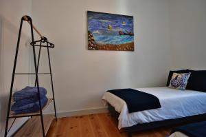 卡斯卡伊斯Casa Joana B&B的一间设有一张床的客房,墙上挂着一幅画