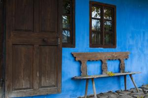 MicloşoaraCount Kálnoky's Transylvanian Guesthouses的一道门和蓝墙前的长凳