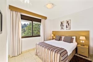 米哈斯麦克唐纳拉埃尔米塔度假酒店的一间卧室设有一张大床和一个窗户。