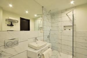第比利斯Tekla Palace By Urban Hotels的白色的浴室设有水槽和淋浴。