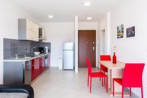 梅杜林Apartment SALE EL SOL的厨房以及带红色椅子和桌子的用餐室