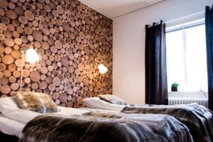 SaxnäsMarsfjäll Mountain Lodge Hotell的墙上木柴的客房内的两张床