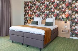阿姆斯特尔芬Best Western Plus Hotel Amstelveen的一间卧室设有一张带花卉墙壁的大床