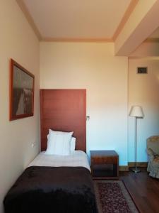 塔布阿苏多佩哥乡村酒店的一间卧室配有一张大床和木制床头板