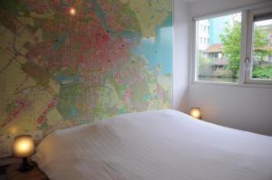 阿姆斯特丹住宿加早餐船上酒店的卧室配有一张白色大床,墙上有地图