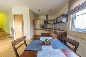 维尔纽斯Apartments Ameda的厨房配有桌子、两把椅子和窗户