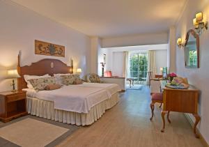 丰沙尔Quintinha Sao Joao Hotel & Spa的一间带一张大床的卧室,位于带桌子的房间