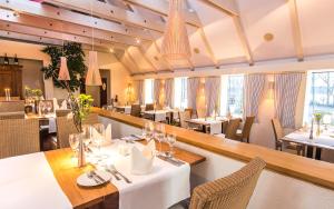 瓦伦克莱斯米尔酒店的餐厅设有白色的桌椅和窗户。